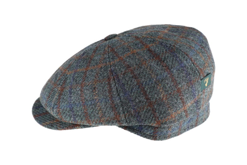 A classic flat cap in a textured blue and brown tweed plaid pattern, shown from a three-quarters angle on a plain white background.