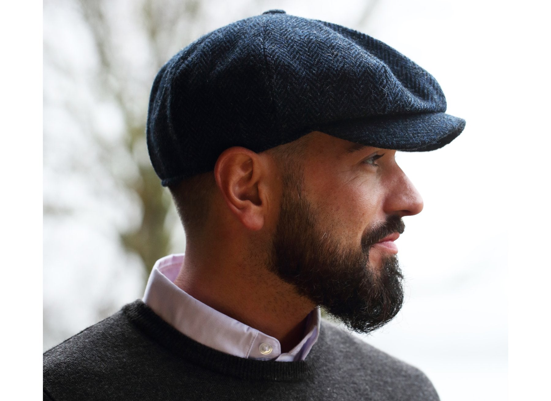 Man wearing a Blue and Black Herringbone Donegal Tweed Peaky Blinders Style Cap by Hanna Hats of Donegal.