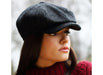 woman wearing a Black and Charcoal Donegal Tweed Peaky Blinders Style Cap by Hanna Hats of Donegal.